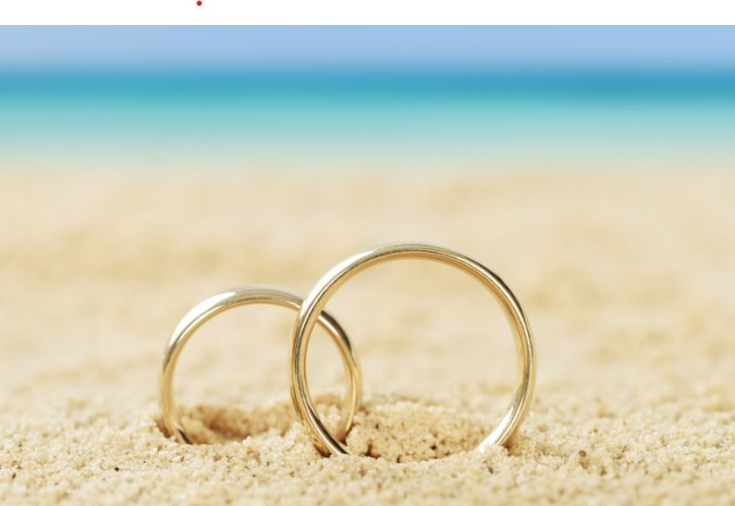 Two gold rings in the sand of the beach. 